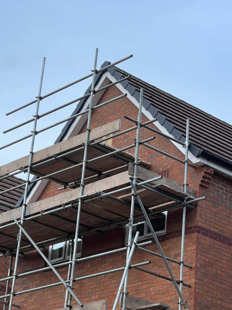 This is a photo of a roof which has just been repaired. There is a scaffold located at the gable end for access onto the roof. Works carried out by Knighton Roofing Repairs