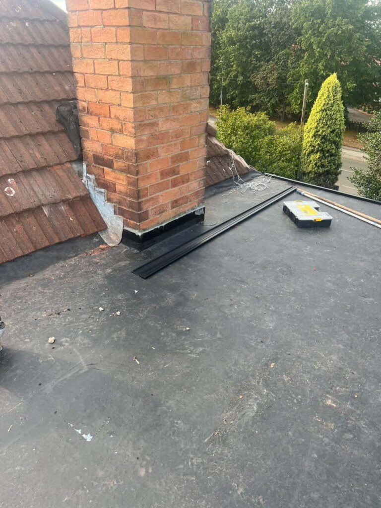 This is a photo of a flat roof which has just been repaired, there is also a chimney stack and some leadwork has also been dressed. Works carried out by Knighton Roofing Repairs